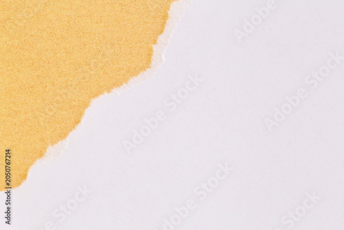 white sheet of paper with torned corner against golden cardboard