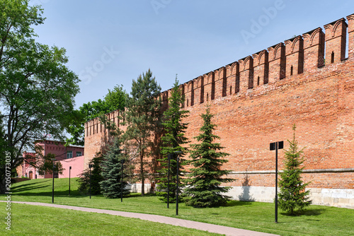 Bild auf Leinwand Ancient Smolensk fortress wall made of red brick with battlements in green park,