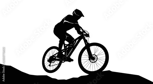 Silhouette of a mountain biker riding downhill on a trail.