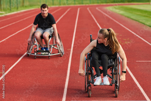 Cuadro en lienzo Two Wheelchair Athletes Racing on Outdoor Track Practicing Paralympic Training a