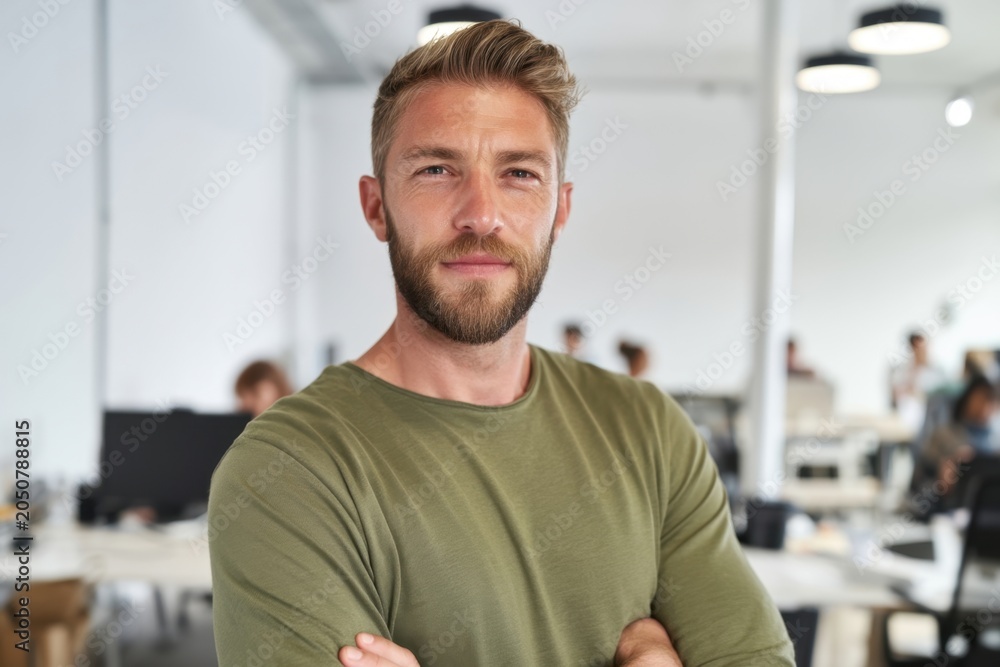 Obraz premium The man in green shirt standing confidently in modern open plan office with colleagues