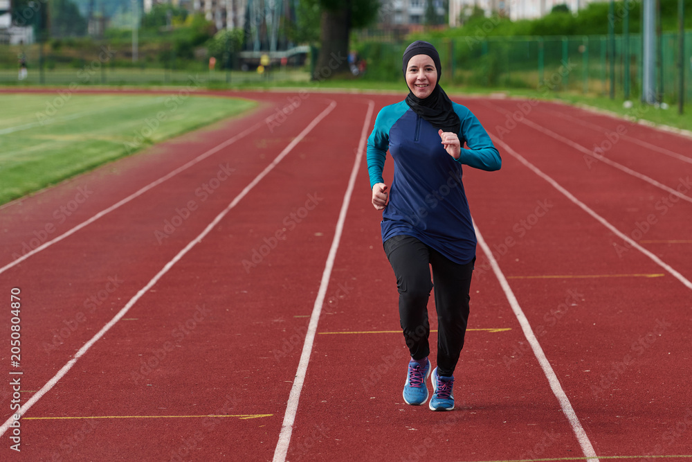 Obraz premium Muslim Woman Running On Outdoor Track Wearing Hijab And Sportswear For Fitness And Wellness