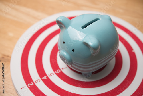 Fényképezés Piggy bank is in center of dartboard
