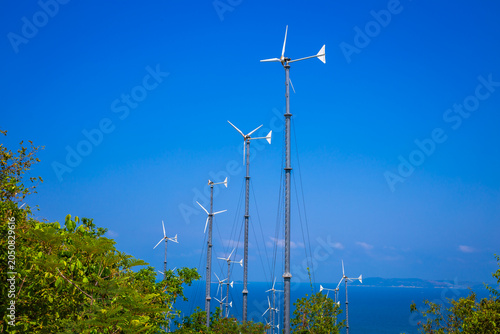 Wind turbines generating electricity on mountain with blue sky at Koh Larn, Pattaya, Chonburi, Thailand