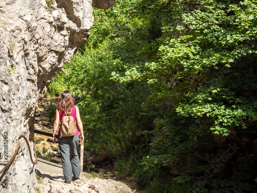 Female hiker walking along limestone trail in Turda Gorge