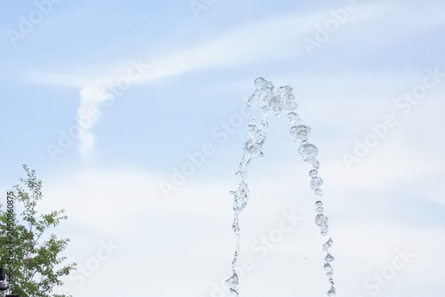 Fountain Water Jets Arching Against Bright Blue Sky