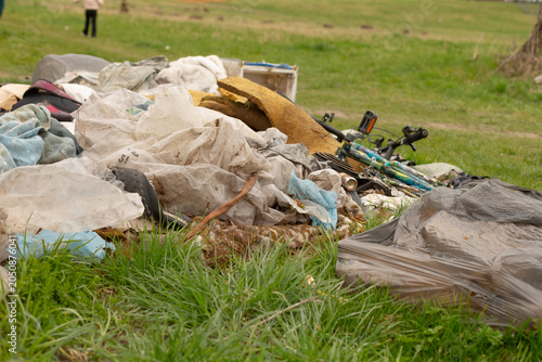Canvastavla A large heap of discarded household waste sits on a grassy field, including torn