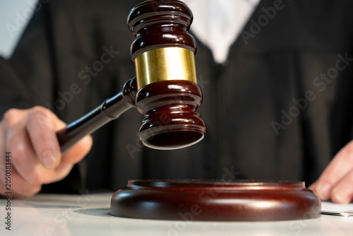 Obraz na plátně Courtroom scene shows a judge holding a gavel while presiding over a case in a l