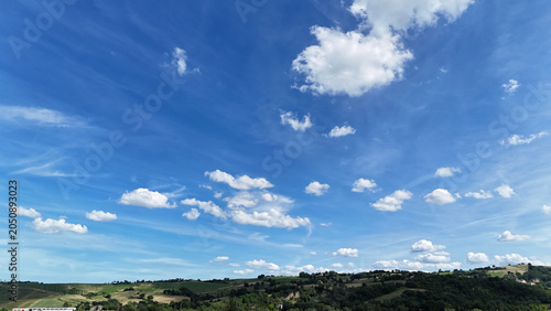 Cuadro en lienzo Colline verdi riprese in ampia panoramica sotto un cielo azzurro con nuvole bian