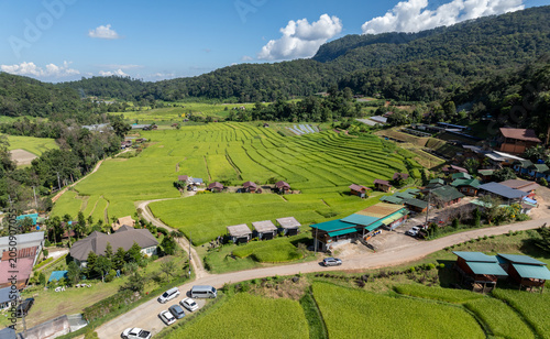 Fotografie A scenic aerial view of the Mae Klang Luang rice terraces in Chiang Mai, Thailand, showcasing the vibrant green landscape and traditional Karen village homes