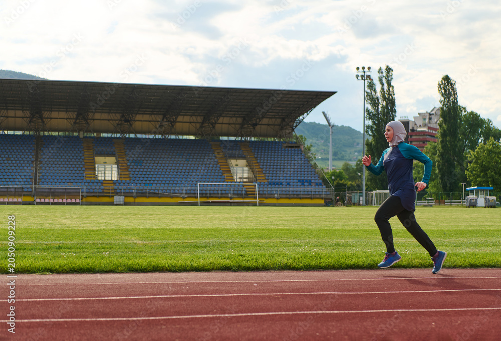Obraz premium Female Runner In Hijab Training On Stadium Track For Fitness And Healthy Active Lifestyle