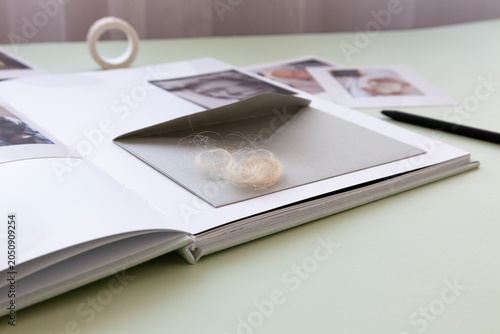 Fotografia Lock of baby hair stored in keepsake envelope inside memory album