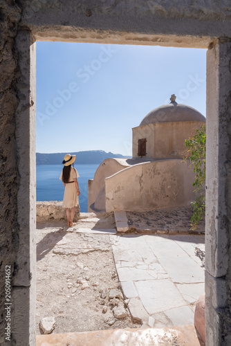 Young woman exploring the ruins of Fort Londsa and enjoying the view of the sea, Oia, Santorini, Greece