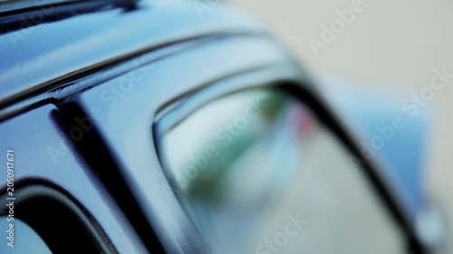 Extreme close-up shot capturing rapid vibration of car door frame, caused by powerful subwoofer bass frequencies. Visible shaking and distortion highlight impact of high-volume car audio system.