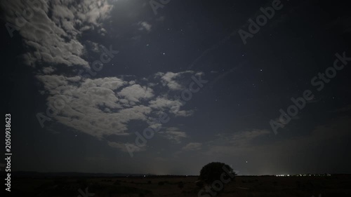Night sky timelapse with moving stars and drifting clouds.