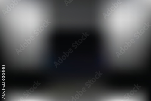 A close-up captures a person holding a sleek laptop on a wooden desk indoors.