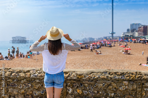 Valokuva Rear view of a woman looking at the beach of Brighton in East Sussex, England, d