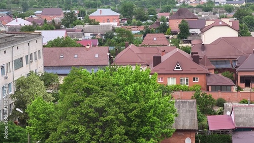 Aerial view of residential neighborhood with red roofs and green trees in summer
