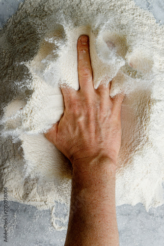 Foto The pizza maker's hand accidentally lands on the flour and makes an obscene gesture with the middle finger raised