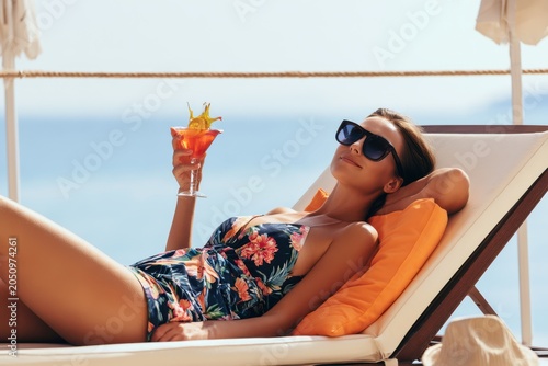 Woman Unwinding on a Lounger with Tropical Drink