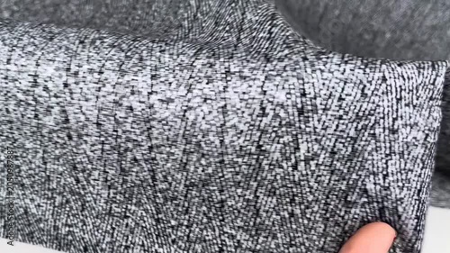 Gray herringbone knit fabric with a soft fleecy side and smooth texture presenting elastic properties and density suitable for warm apparel manufacturing and textile industry.