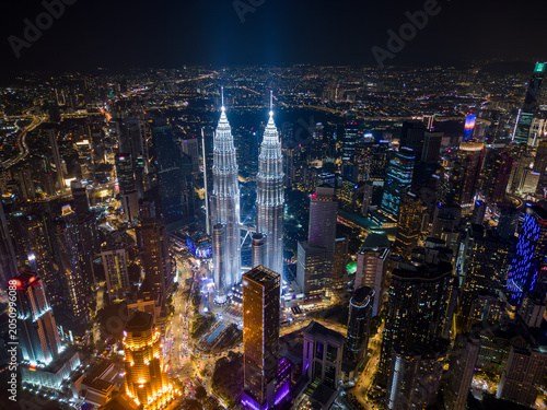 Photography Aerial drone view of Kuala Lumpur downtown with illuminated skyscrapers and the city skyline at night, Malaysia
