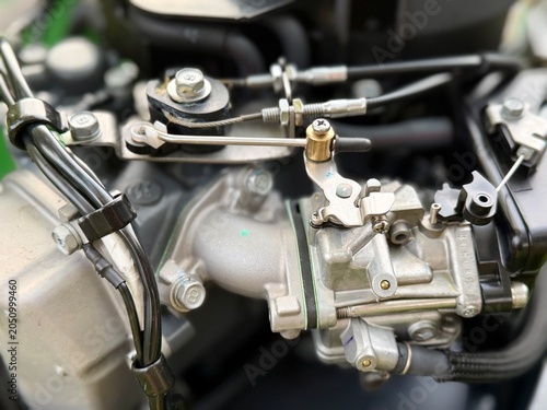 Fotografía A close-up of a mechanic's hand adjusting a small carburetor linkage on a boat's outboard motor engine
