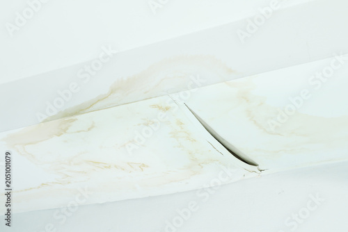 damaged ceiling with severe water stains, mold, and cracks caused by rain leaking through the roof. The image shows moisture damage and fungus growth from a ceiling leak problem water leaking ceiling