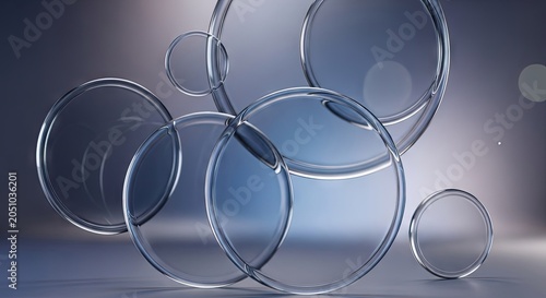 Transparent glass rings overlapping on blue abstract background.