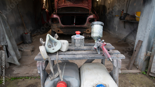 Tools and supplies used for auto repair in a garage during a work session on a car project