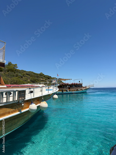 Boats and yachts floating on calm blue water under a clear sky. Scenic coastal view with peaceful sea, summer atmosphere, maritime travel, and leisure activities in a beautiful seaside destination.