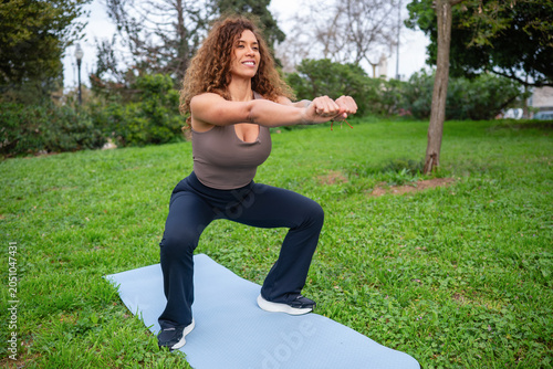 Fotografie Woman doing outdoor fitness squat exercise in park