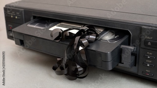 videotape. An old VCR ejecting a slightly tangled videotape in a close-up view. product launch decks, UI/UX mockups, designed for data visualization dashboards and holographic UIs.