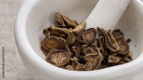 valerian. Dried slices of valerian root scattered in a white ceramic mortar with soft natural side lighting. gardening catalogs, home-decor guides, designed for home decor and floral branding.