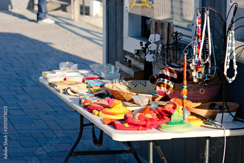 Photography Handmade crafts and jewelry are displayed on a sidewalk vendor table in Long Beach
