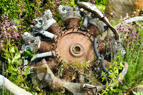 Foto Abandoned rusty radial aircraft engine in overgrown field historical aviation re