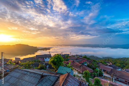 Foto Stunning sunrise over Akha Pa Kluay mountain village in Doi Tung, Chiang Rai, Thailand, featuring a majestic sea of fog covering the valley under a golden morning sky
