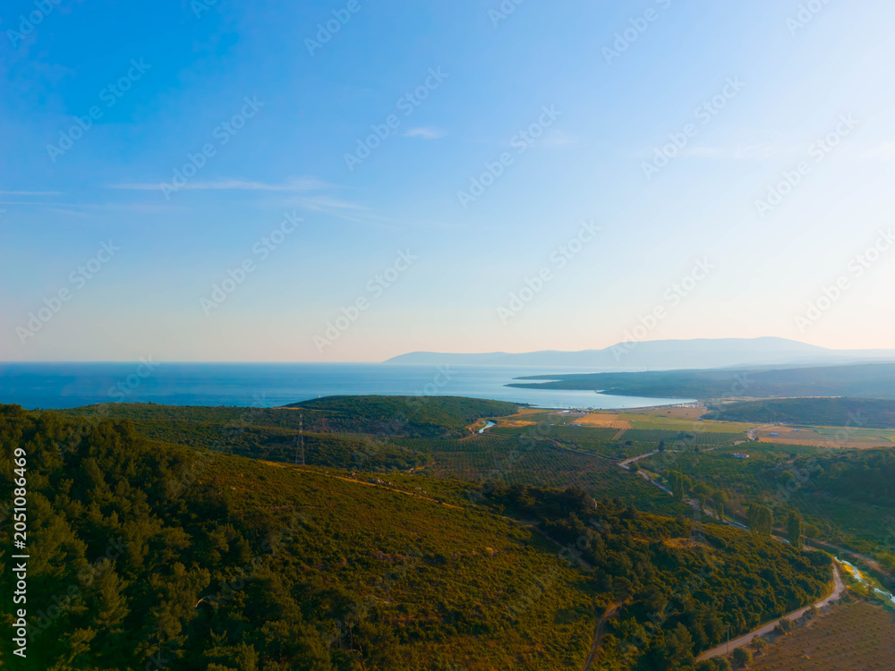 Fototapeta premium Aerial view of coastal mountains, valley, and blue aegean sea