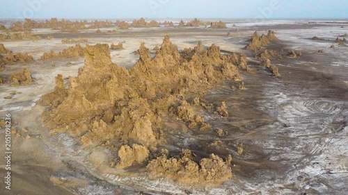A drone view of towering limestone formations along the surreal shoreline of Lac Abbe, set in Djibouti's remote desert.