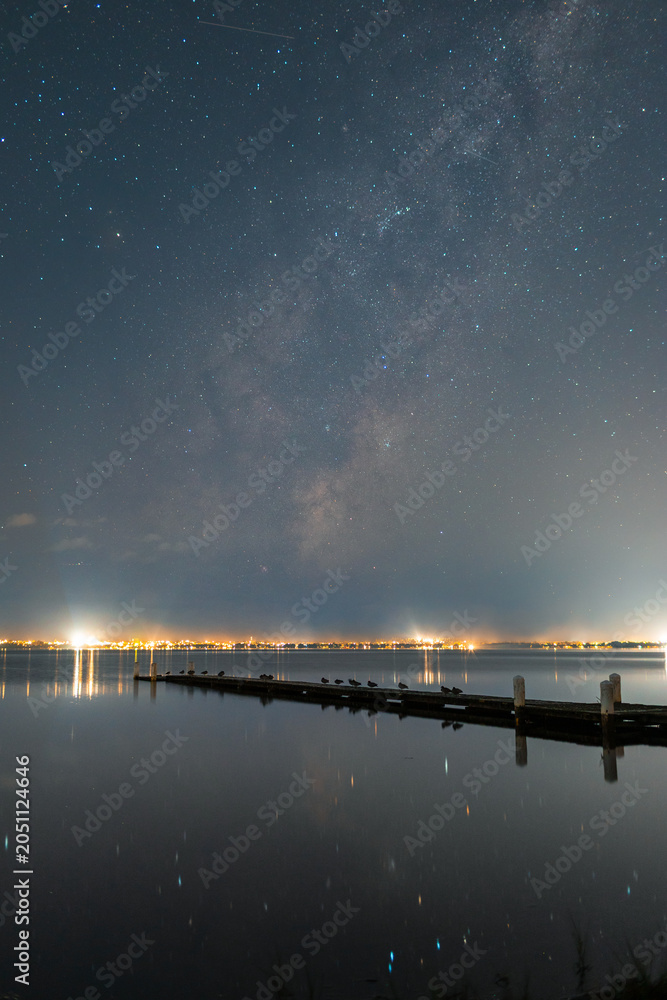 Obraz premium View of milky way rising above the jetty by the lake.