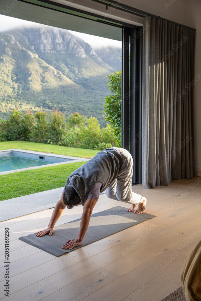 Obraz premium Yoga mat is lying next to open sliding glass door, sunlight warming wooden floor and pool