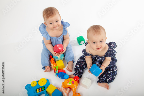Happy Babies Playing with Colorful Educational Toys on White Background – Smiling Infants in Stylish Outfits Engaged in Learning and Fun, Perfect for Parenting, Early Childhood, or Toy Ads