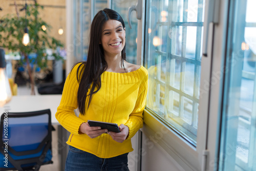 Konstfotografi Happy Female Entrepreneur with Digital Tablet Standing by Window