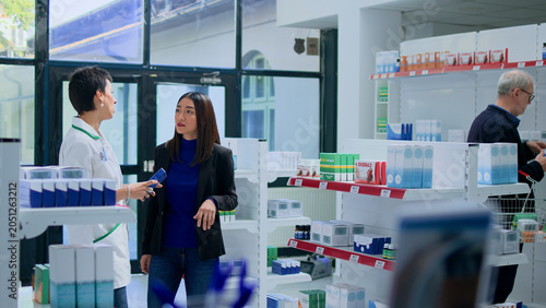 Foto Asian woman in drugstore asking qualified pharmacist for medical recommendation, with licensed druggist helping customer pick pharmaceutical product to counteract illness