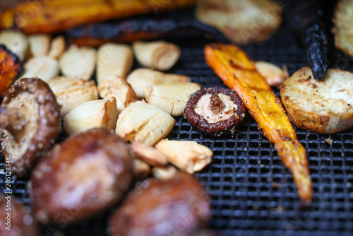 Farm fresh garden vegetables cooking on a pellet grill smoker for a vegetarian dinner. The healthy food is colorful and packed with vitamins and garden nutrients. Delicious!