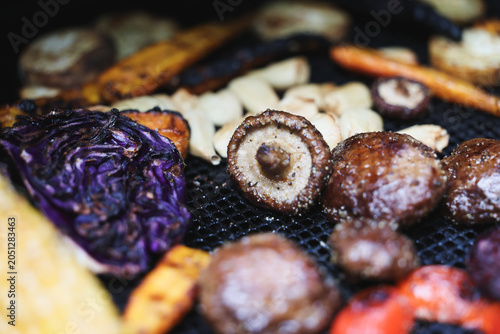 Farm fresh garden vegetables cooking on a pellet grill smoker for a vegetarian dinner. The healthy food is colorful and packed with vitamins and garden nutrients. Delicious!