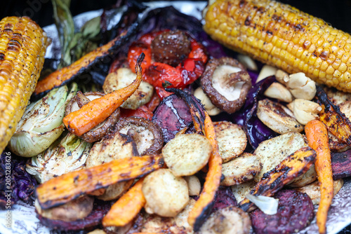 Farm fresh garden vegetables cooking on a pellet grill smoker for a vegetarian dinner. The healthy food is colorful and packed with vitamins and garden nutrients. Delicious!