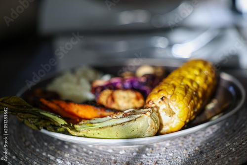 Farm fresh garden vegetables cooking on a pellet grill smoker for a vegetarian dinner. The healthy food is colorful and packed with vitamins and garden nutrients. Delicious!