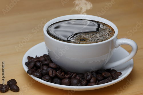 Hot black coffee in white cup with coffee beans  on table background.