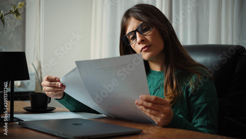 Foto Young Hispanic secretary analyzing work documents in the office
